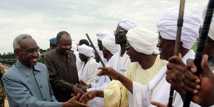 The then-Sudanese second vice president Ali Osman Taha (left) and the then-state governor Ahmed Haroun (centre) shake hands with town officials upon their arrival at Al Majlad in the state of South Kordofan in central Sudan on August 4, 2010 (AFP photo)