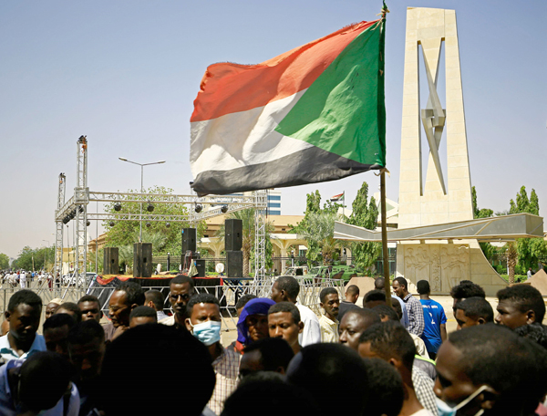 A protester holds a national flag during a sit-in demanding the dissolution of Sudan’s post-dictatorship interim government, outside the presidential palace in central Khartoum on Monday  (AFP photo)