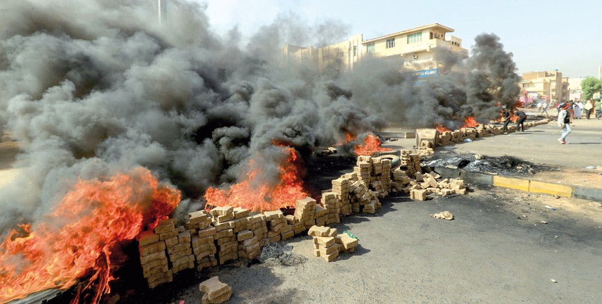 Sudanese protesters use bricks and burning tyres to block 60th Street in the capital Khartoum, to denounce overnight detentions by the army of members of Sudan’s government, on Monday (AFP photo)