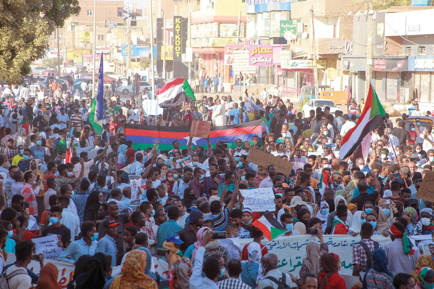 Sudanese demonstrators wave flags during a rally in Khartoum Bahri, on Monday, to protest a deal that saw the prime minister reinstated after his ouster in a military coup in October (AFP photo)