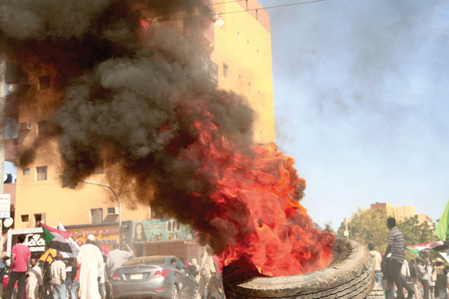 Sudanese protesters burn a tyre at the scene of confrontations with security forces in the capital Khartoum, on Saturday (AFP photo)