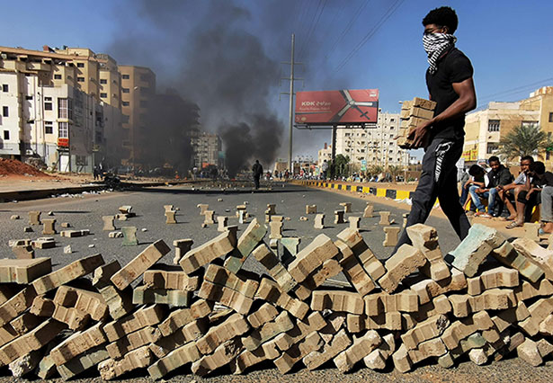 Protesters use bricks to block a street in the Sudanese capital Khartoum, during a demonstration against the killings of dozens in a crackdown since last year's military coup, as US diplomats pressed for an end to the violence, on Thursday (AFP photo)