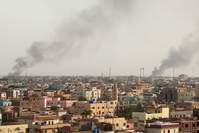 Smoke billows behind buildings in Khartoum on Sunday, as fighting between Sudan's warring generals intensifies (AFP photo)