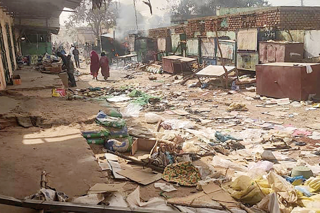 People walk among scattered objects in the market of El Geneina, the capital of West Darfur, on April 29 (AFP photo)