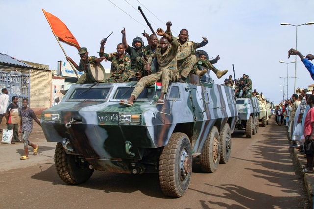 People cheer members of Sudan's armed forces taking part in a military parade held on Army Day in Gadaref on August 14  (AFP photo)