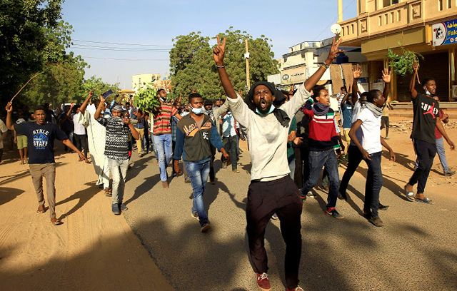 Sudanese demonstrators chant slogans as they march along the street during anti-government protests in Khartoum, Sudan, on Tuesday (Reuters photo)