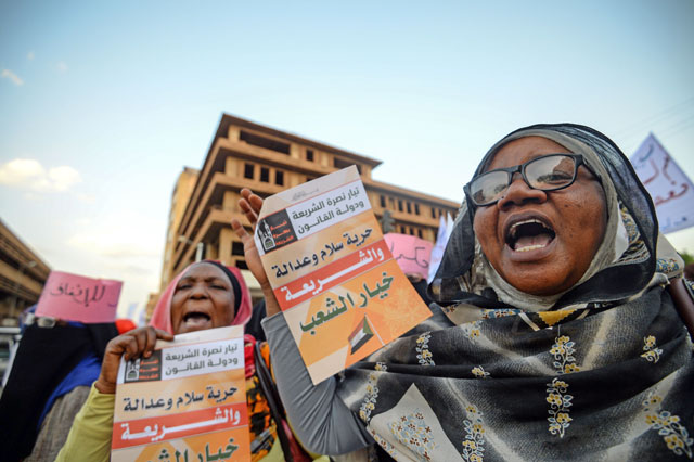 Supporters of Sudanese Islamist movements shout slogans and hold placards with writings reading in Arabic ‘Sharia is people’s choice’ during a rally in front of the Presidential Palace in downtown Khartoum, on May 18 (AFP photo)