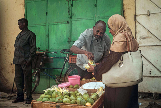A tailor works with customers at a market street in the Sudanese capital Khartoum’s twin city Omdurman on Thursday as life returns to normal in the Sudanese capital Khartoum (AFP photo)