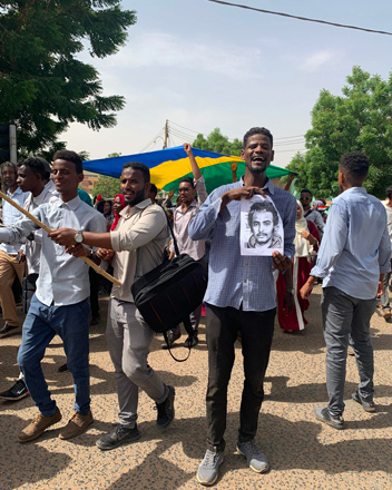 A Sudanese protester chants slogans while holding up a printed portrait of a protester who was killed during past clashes, during a demonstration in the centre of the capital Khartoum, on Tuesday (AFP photo)