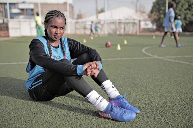 Rayan Ibrahim Rajab, a 22-year-old footballer, rests on an astro-turf pitch during a training with her women's club in the Sudanese capital Khartoum, on Wednesday (AFP photo)