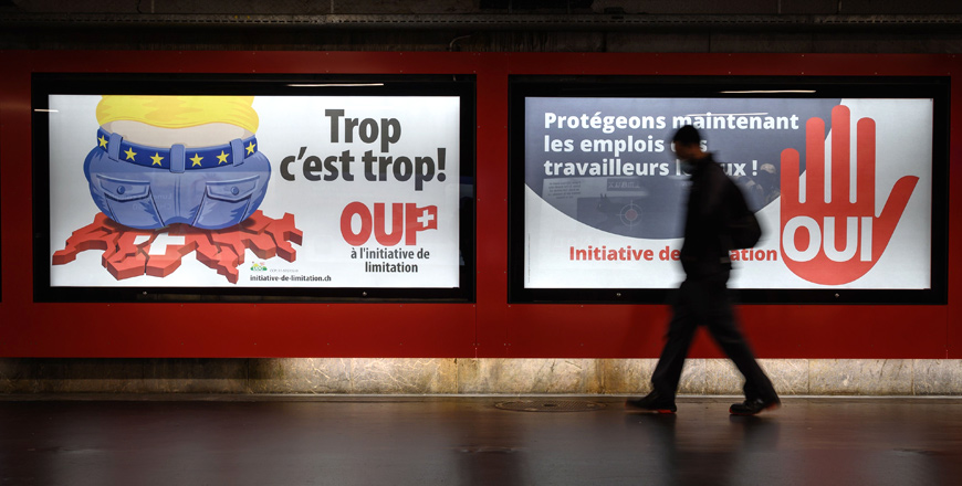A photo taken on September 1in Lausanne shows backlit electoral posters that translates from French as ‘Too much is too much!’ (left) and ‘Protecting the jobs of local workers now’ to advertise a right-wing Swiss People’s Party (SVP)-backed initiative that voted on Sunday (AFP photo)