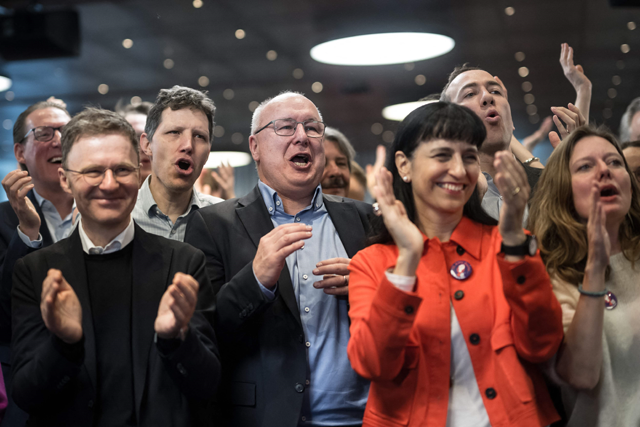 Members of the initiative committee, with President Swiss Federation of Trade Unions (SGS USS) Pierre-Yves Maillard (thirds left), react in Bern on Sunday (AFP photo)
