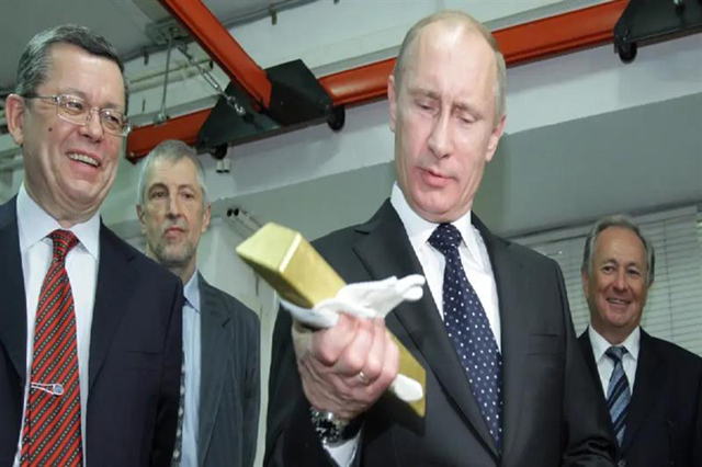 Vladimir Putin holds a gold bar while visiting the Central Bank of Russia, on January 24, 2011 (AFP photo)
