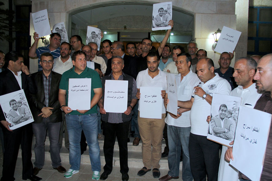 Al Rai employees hold a protest at the daily's premises on Thursday evening in solidarity with journalist Ghazi Mrayat, who has been detained after violating a gag order preventing the publishing of news on a foiled terror plot (Photo by Osama Aqarbeh)