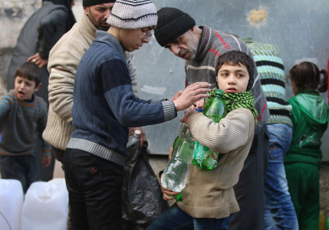 Civilians fill containers and bottles with water in a rebel-held besieged area of Aleppo, Syria, on Saturday  (Reuters photo)