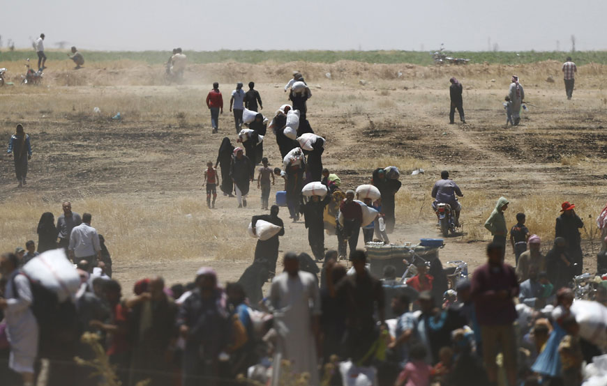 Syrian refugees wait behind the border fences as they are pictured from the Turkish side of the border near Akcakale in Sanliurfa province on Wednesday (Reuters photo)