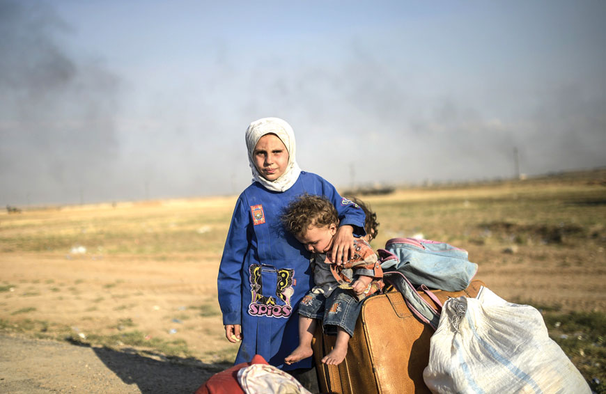 Syrian children wait after entering in Turkey at the Akcakale crossing gate between Turkey and Syria in Sanliurfa province on Tuesday (AFP photo)