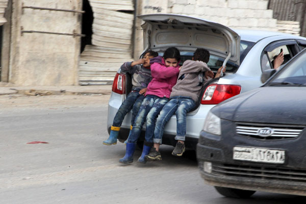 Children ride in the trunk of a car in Kafr Hamra village, northern Aleppo countryside, Syria, February 27 (Reuters photo)