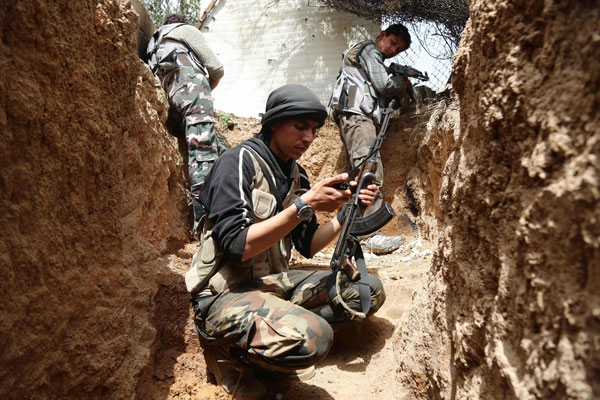 Fighters from the Jaish Al Islam (Islam Army), the foremost rebel group in Damascus province fiercely opposed to both the Syrian regime and the Daesh terror group, hold a position in the rebel-held town of Douma, on the eastern edges of the capital, on Sunday (AFP photo)