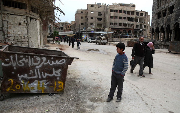 A Syrian boy looks at anti-election graffiti describing the dust bin as ballot box for parliamentary elections in the rebel-held city of Douma on the eastern outskirts of the capital on Wednesday (AFP photo)
