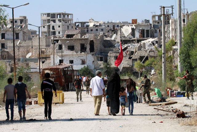 Syrian government forces secure a street as civilians come back to the neighbourhood of Bani Zeid on Aleppo’s northern outskirts, on Friday, a day after Syrian government forces took control of the previously rebel-held district (AFP photo)