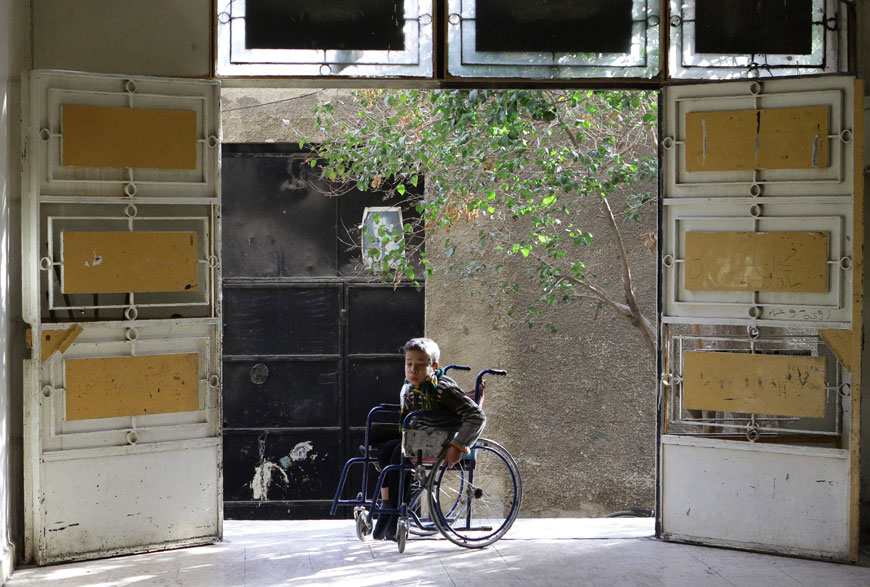 A child is seen in the doorway of the Ateiyah Al Ansary government-run shelter for displaced Syrians, in the Al Zahera neighbourhood of Damascus, on Thursday  (AFP photo)
