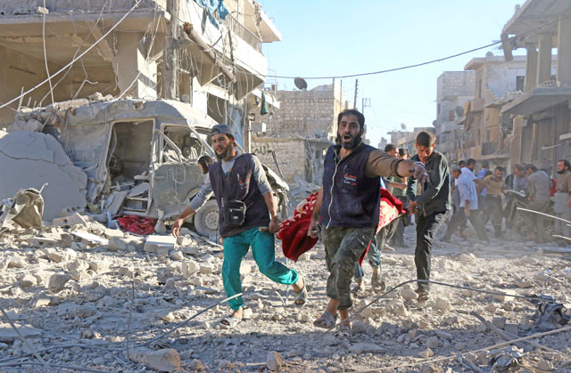 Syrian volunteers carry an injured person on a stretcher following reported Syrian government air strikes on the rebel held neighbourhood of Heluk in Aleppo on Friday (AFP photo)