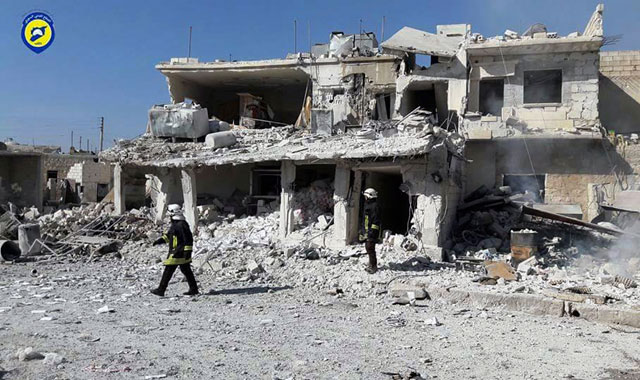 This photo provided by the Syrian civil defence White Helmets, which has been authenticated based on its contents and other AP reporting, shows civil defence workers walk past damaged buildings after air strikes hit in Abian Saman town, in rural western Aleppo province, Syria, on Saturday (AP photo)