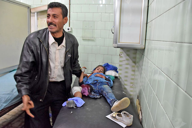 A Syrian man reacts next to an injured girl at a hospital in the government-held side of west Aleppo on Sunday, following reported rocket fire by the rebel fighters that hold the eastern part of the city (AFP photo)