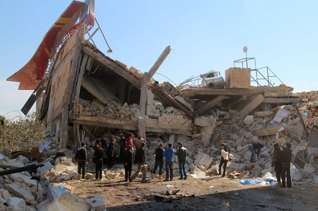 People gather around the rubble of a hospital supported by Doctors Without Borders near Maaret Al Numan, in Syria’s northern province of Idlib, on Monday, after the building was hit by suspected Russian air strikes (AFP photo)