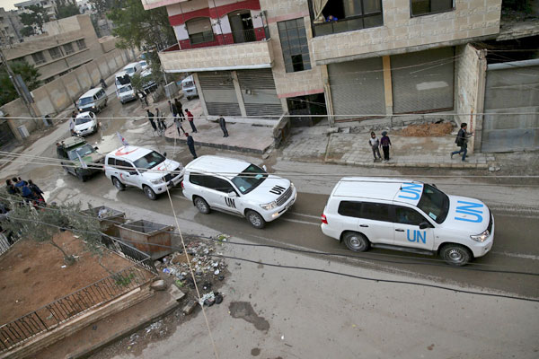 Syrian Arab Red Crescent and UN vehicles drive through the rebel-held besieged city of Douma towards the besieged town of Kafr Batna to deliver aid, on the outskirts of Damascus, Syria, on Tuesday (Reuters photo)