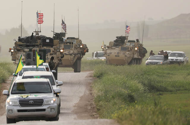 Kurdish fighters from the People’s Protection Units head a convoy of US military vehicles in the town of Darbasiya next to the Turkish border in Syria on April 28 (Reuters photo)