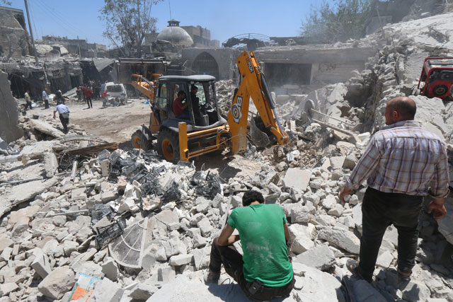 Civil defence members work at a site hit by a barrel bomb in the rebel held area of old Aleppo, Syria, on Monday (Reuters photo)