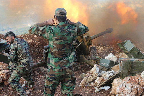 In this photo taken on Saturday, Syrian army personnel fire a cannon in Latakia province, about 19km from the border with Turkey, in Syria (AP photo)