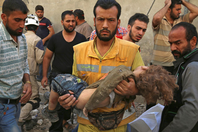 A medic holds a dead child after air strikes in the rebel held Karam Houmid neighbourhood in Aleppo, Syria, on Tuesday (Reuters photo)