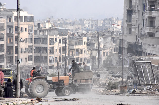Syrians use a tractor to collect belongings in the former rebel-held Zebdiye district in the northern Syrian city of Aleppo on Friday after Syrian government forces retook control of the whole embattled city (AP photo)