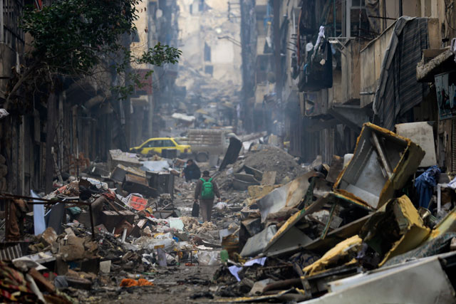 Residents walk through the destruction of the once rebel-held Salaheddine neighbourhood in the eastern Aleppo, Syria, on Friday (AP photo by Hassan Ammar)