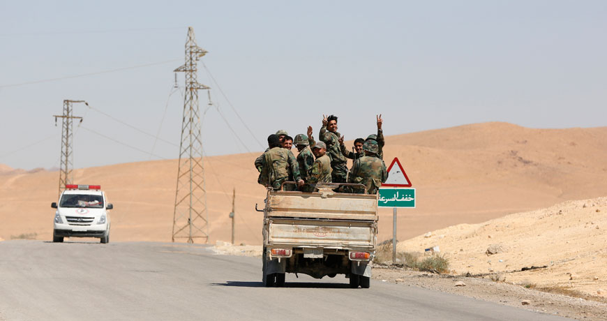 Syrian soldiers flash the V-victory sign in the ancient city of Palmyra on Friday. An Associated Press crew visiting the town Friday witnessed firsthand the destruction inflicted by the extremist group on the town’s famed archaeological site, less than a mile away from the modern-day town of the same name, now completely deserted (AP photo)