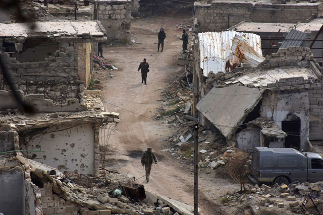 Syrian pro-government troops walk on a street in Aleppo’s eastern Karm Al Jabal neighbourhood as they advance towards Al Shaar neighbourhood on Monday during their offensive to retake Syria’s second city (AFP photo)
