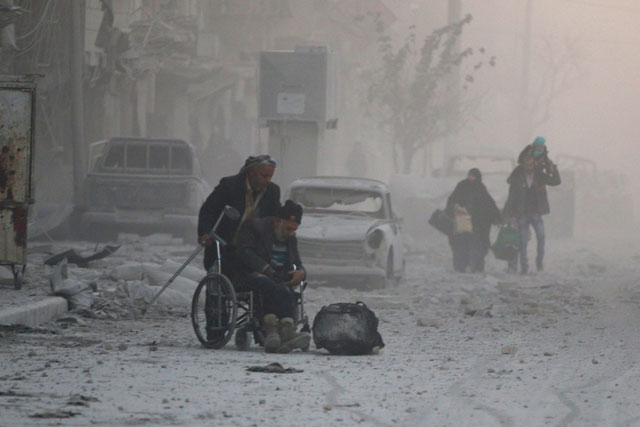 A man on a wheelchair flees with others into the remaining rebel-held areas of Aleppo, Syria, on Friday (Reuters photo)
