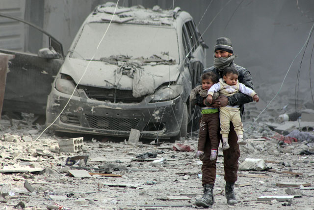 A Syrian man carries two wounded children after warplanes  reportedly belong to Assad regime forces carried out air strikes to a marketplace and a settlement in Arbin town of Eastern Ghouta region in Damascus, Syria, on Wednesday (Anadolu Agency photo)