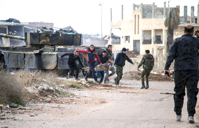 Syrians carry an injured youth on a stretcher in the rebel-held area of Daraa, in southern Syria, on Saturday (AFP photo)