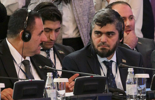 Chief opposition negotiator Mohammad Alloush (right) of the Jaish Al Islam (Army of Islam) rebel group speaks with his colleague during the second session of Syria peace talks at the Rixos President Hotel in Astana on Thursday (AFP photo)