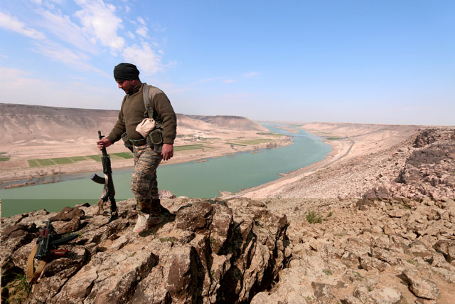 A Syrian Democratic Forces fighter poses for a picture near the Euphrates River, north of Raqqa city, Syria, on Wednesday (Reuters photo)
