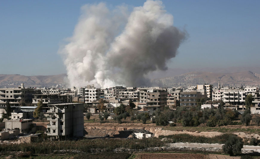 Smoke billows from buildings following a reported air strike in Damascus’ rebel-held suburb of Zamalka on Sunday (AFP photo)