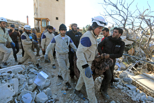 People and Civil Defence members carry a dead body removed from a destroyed Medecins Sans Frontieres-supported hospital hit by missiles in Maarat Numan, Syria, on Tuesday (Reuters photo)
