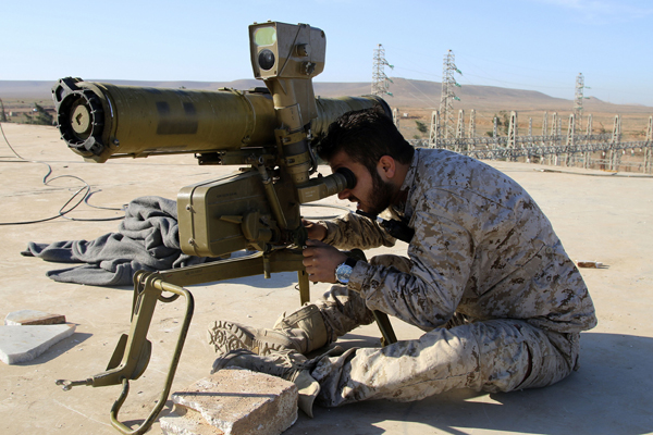 In this photo taken on Wednesday, a Syrian government soldier takes his position with an anti-tank rocket launcher, preparing to fire against Daesh terror group positions in the province of Raqqa, Syria (AP photo)