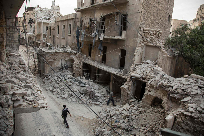 A Syrian man walks past destroyed buildings on Monday in Aleppo’s Bab Al Hadid neighbourhood which was recently targeted by regime air strikes (AFP photo)