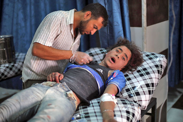 An injured Syrian boy receives treatment at a makeshift hospital following reported air strikes in the rebel-held town of Outaya, east of the capital Damascus, on Thursday (AFP photo)