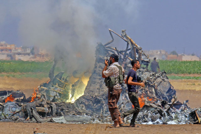 Men inspect the wreckage of a Russian helicopter that had been shot down in the north of Syria’s rebel-held Idlib province, Syria, on Monday (Reuters photo)